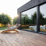 Femme lisant sur terrasse avec vue sur nature