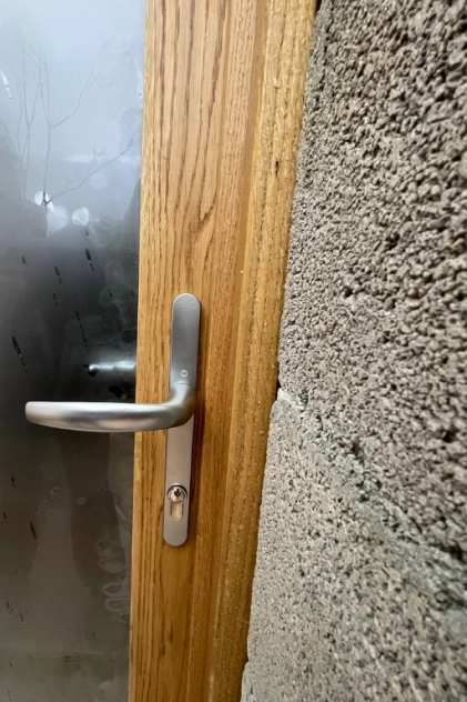 Porte en bois avec poignée métallique moderne.