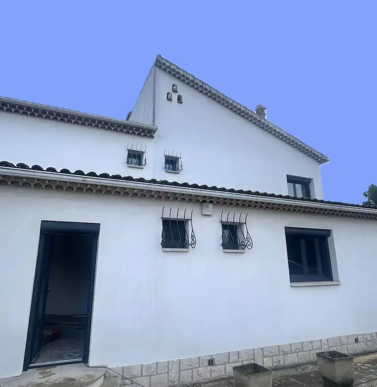 installation d'une porte d'entree en tunnel charleval Maison blanche avec toit en tuiles et fenêtres grillagées.